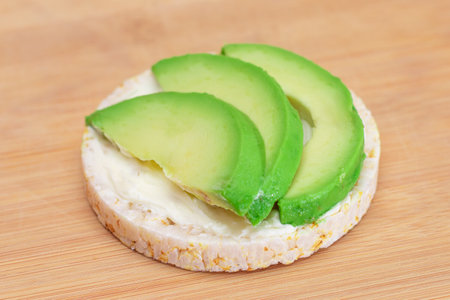 Rice Cake Sandwich with Fresh Avocado and Cream Cheese on Bamboo Cutting Board. Easy Breakfast. Diet Food. Quick and Healthy Sandwiches. Crispbread with Tasty Filling. Healthy Dietary Snackの写真素材
