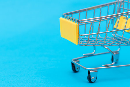 Empty Yellow Shopping Cart on Blue Background. Shopping, Trade and Market Conceptの写真素材