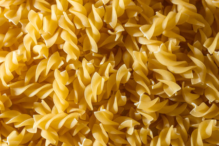 Uncooked Fusilli Pasta: A Culinary Canvas of Spiral Macaroni, Creating a Lively and Textured Background for Gourmet Cooking. Dry Pasta. Raw Macaroni - Top View, Flat Layの写真素材
