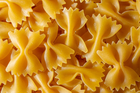 Uncooked Farfalle Pasta: A Culinary Canvas of Bow-Tie Macaroni, Creating a Lively and Textured Background for Gourmet Cooking. Dry Pasta. Raw Macaroni - Top View, Flat Layの写真素材
