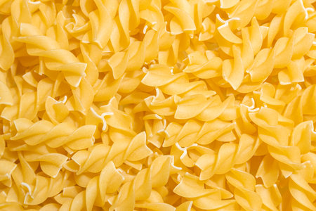 Uncooked Fusilli Pasta: A Culinary Canvas of Spiral Macaroni, Creating a Lively and Textured Background for Gourmet Cooking. Dry Pasta. Raw Macaroni - Top View, Flat Layの写真素材