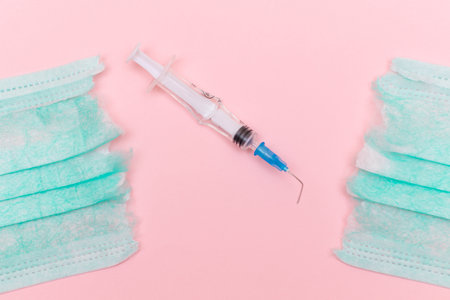 Anti Vaccine Movement and Anti Mask Concept - Broken Medical Syringe and Green Torn Medical Face...