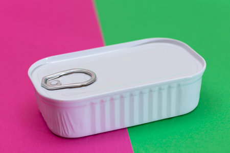 Tin Can on Split Green and Cyan Background. Canned Food. Aluminum Can for Safe and Long Term Storage...