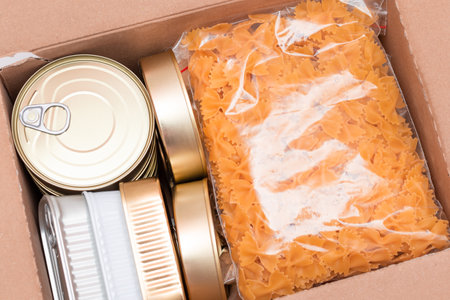 Food Reserves or Donation Box: Carton Box with Canned Food, Cereals and Grocery. Emergency Food Storage in Case of Crisis. Free Social Help, Blessings and Care. Strategic Food Suppliesの写真素材