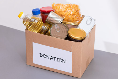 Donation Box of Free Food. Carton Box with Canned Food, Cereals and Grocery. Meal Reserves. Emergency Food Storage in Case of Crisis. Free Social Help, Blessings and Care. Strategic Food Suppliesの写真素材