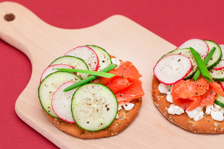 Crispy Cracker Sandwiches with Fresh Salmon, Cucumber, Radish, Cottage Cheese and Green Onions. Easy Breakfast. Quick and Healthy Sandwiches. Crispbread with Tasty Filling. Healthy Dietary Snackの写真素材