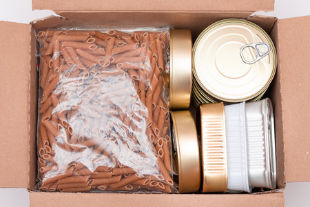 Food Reserves or Donation Box: Carton Box with Canned Food, Cereals and Grocery. Emergency Food Storage in Case of Crisis. Free Social Help, Blessings and Care. Strategic Food Suppliesの写真素材