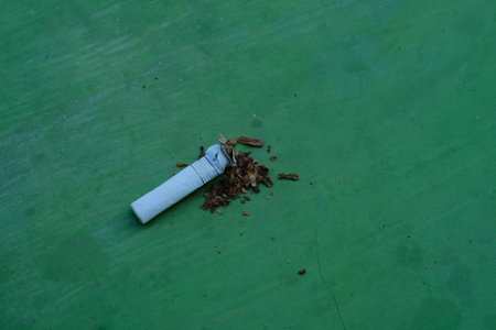 Cigarette butts on green background, closeup of photoの写真素材