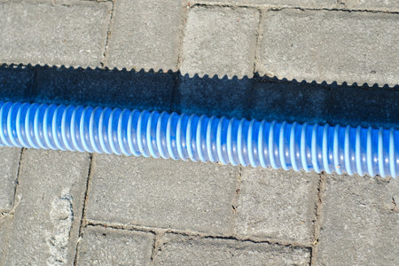 Blue plastic pipe for heating system on the pavement. Close-up.の写真素材