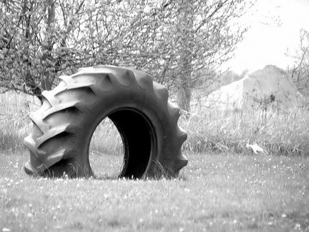 A Huge Tire, half buried in the ground for kids to play on and inの写真素材