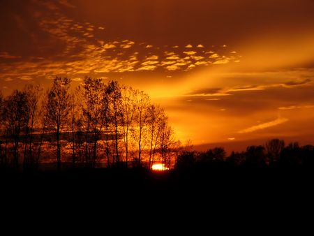 Blazing red and orange sunset with unusual cloudsの写真素材