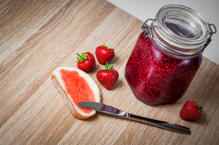 Tasty raspberry jam in jar isolated on tableの写真素材