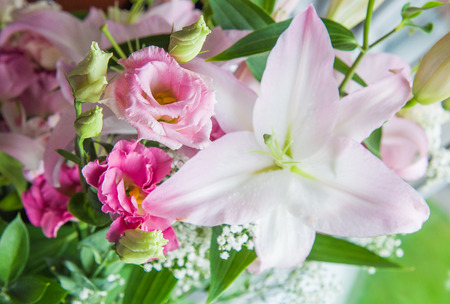 beautiful bouquet of eustoma, lilies, roses flowers on green backgroundの写真素材