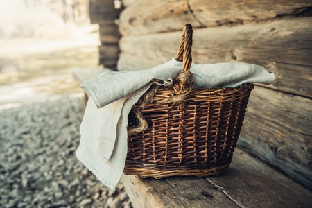 Basket with towel on the wooden bench in the Riga Ethnographic open air Museum , Latviaの写真素材
