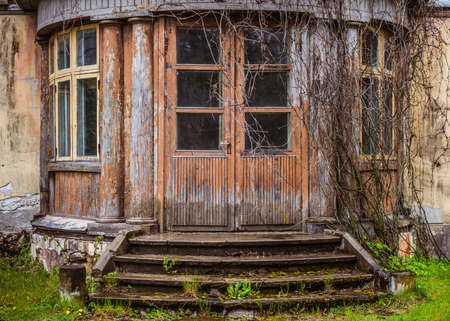 Old brown wooden door with window panes. Old wooden building with weathered doorwayのeditorial素材