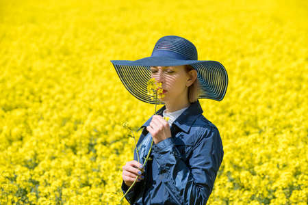 Young woman stands in a rape fieldの写真素材