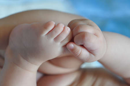 Small baby feet and hands on light blue background.の写真素材