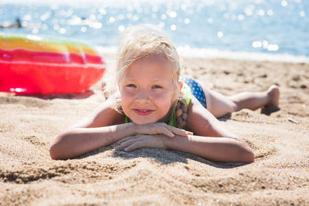 Portrait of little girl with inflatable rubber circle on beachの写真素材