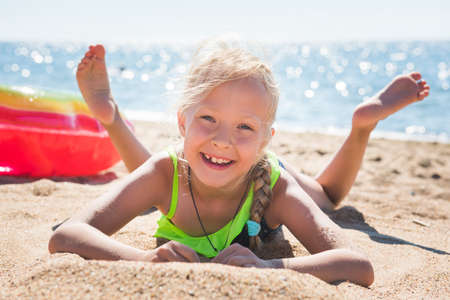 Portrait of little girl with inflatable rubber circle on beachの写真素材