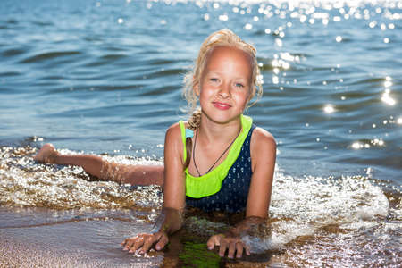 Little girl is laughing and swimming at sea on a sunny dayの写真素材