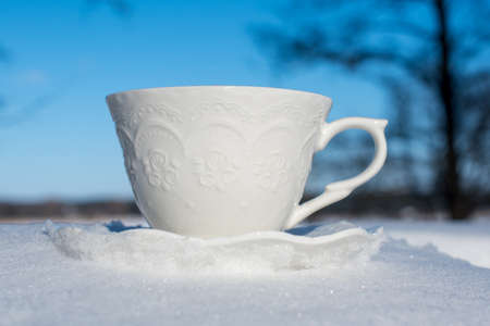 Cup of tea for breakfast on snow background outsideの写真素材