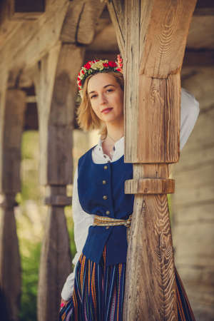 Woman in traditional clothing posing on nature in village.の写真素材