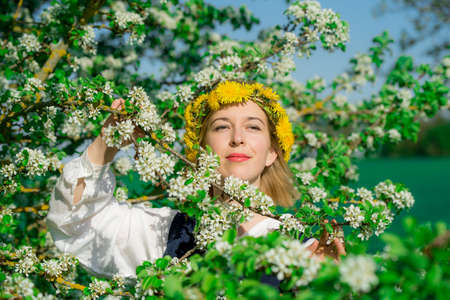 Beautiful feminime woman in national dress with white spring flowersの写真素材