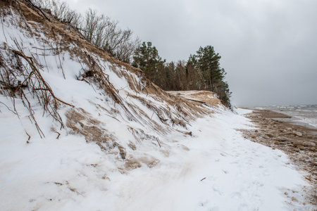 Baltic Sea wild beach is snowy in winter and there are big wavesの写真素材