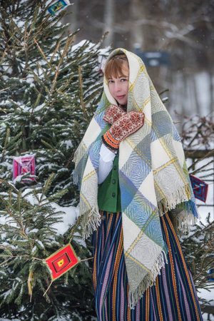 Latvian woman in traditional ethnic clothing posing on nature winter background.の写真素材