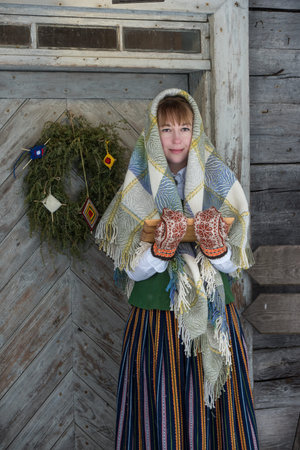 Latvian woman in traditional ethnic clothing posing on nature background in village.の写真素材