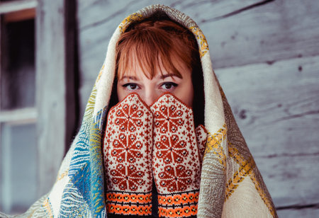 Latvian woman in traditional ethnic clothing posing on nature winter background in village.の写真素材