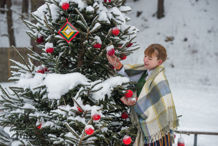 Latvian woman in traditional ethnic clothing posing on nature winter background in village.の写真素材