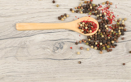Pepper mix in a wooden spoon on wooden background. Top view.の写真素材