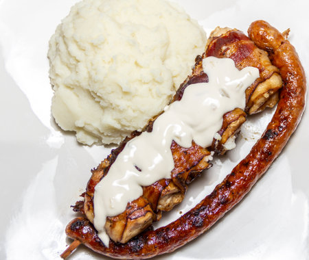grilled chicken with sauce and mashed potatoes on a white plate.の写真素材