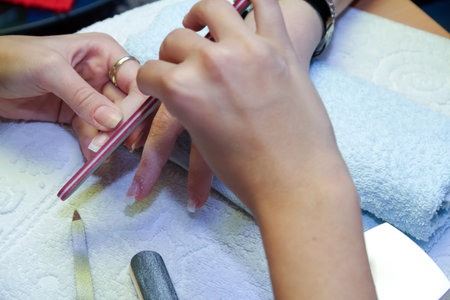 Manicure process in a beauty salon, closeup of handsの写真素材