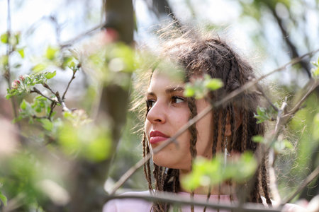 Portrait of a young girl with dreadlocks in the spring garden