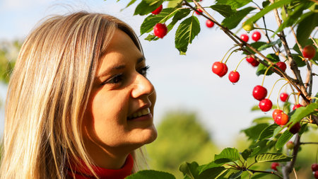 Young woman in the garden with ripe cherries. Selective focus.