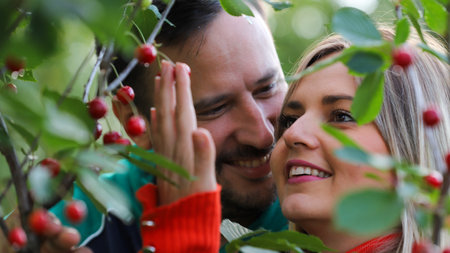 Couple in love looking at cherries in a cherry tree.