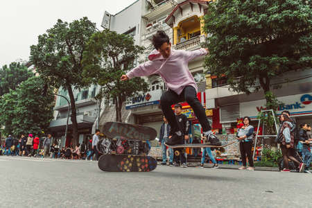 HANOI, VIETNAM - DECEMBER 14, 2018 : Street scene of the Old Quarter of Hanoi during the day. Young people skateboarding in the street.のeditorial素材