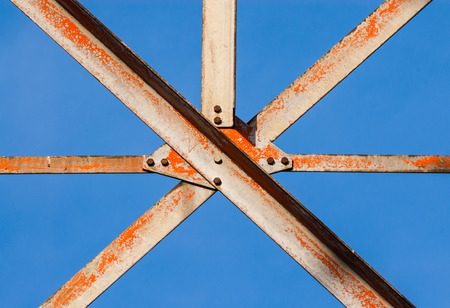 Worn metal girders crossing held together with plates and screws の写真素材