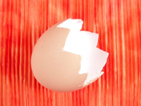 Empty Egg shell on top of a piece of tie dye cloth (vibrant color background)の写真素材