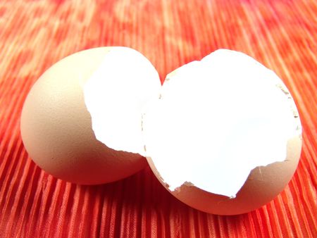 Empty Egg shell on top of a piece of tie dye cloth (vibrant color background)の写真素材
