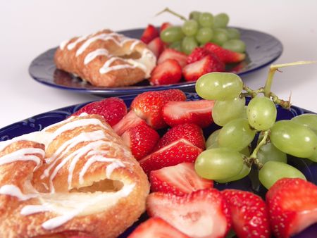 Pastry, grapes and strawberry on a blue plateの写真素材