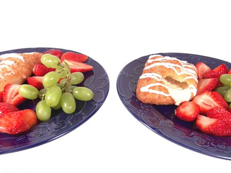 Pastry, grapes and strawberry on two blue platesの写真素材