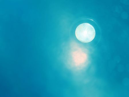 A bright flood light flashing from a blue background symbolize alternate energy from clean sourcesの写真素材