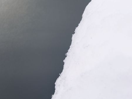Clean Edge of a Pile of Snow on Gray Background                               