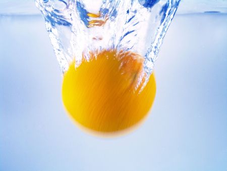 Close-up of water waving and splashing caused by spinning dropping orangeの写真素材