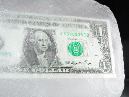 US paper currency (one dollar) frozen in ice representing a downsizing economy, financial crisis, unemployment and investment lose                               の写真素材