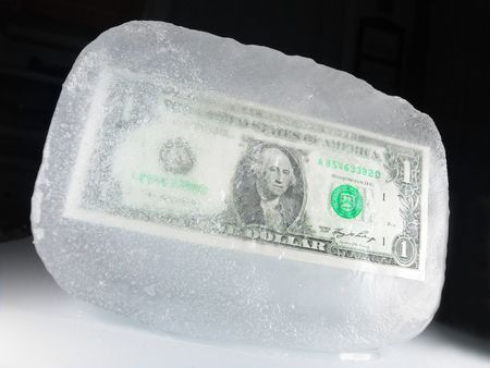 US paper currency (one dollar) frozen in ice representing a downsizing economy, financial crisis, unemployment and investment lose                               の写真素材