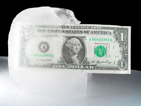 US paper currency (one dollar) in half frozen ice representing a current downsized economy, financial crisis, unemployment and investment lose.  Ice melting could also mean the economy is getting better, coming out from a prior frozen state.              の写真素材